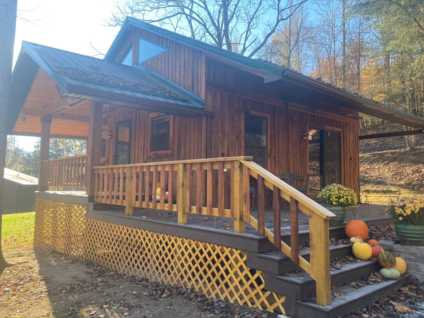The cabin in autumn light, pumpkins lining the porch steps